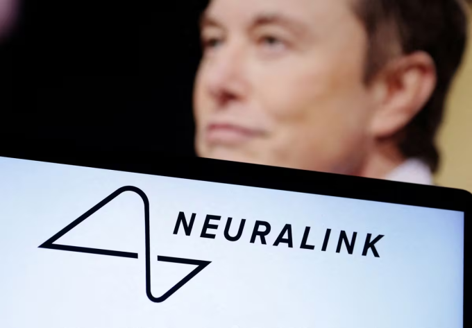 Logo Neuralink hiển thị trên một chiếc laptop, đằng sau là hình ảnh của Musk. Ảnh: Reuters